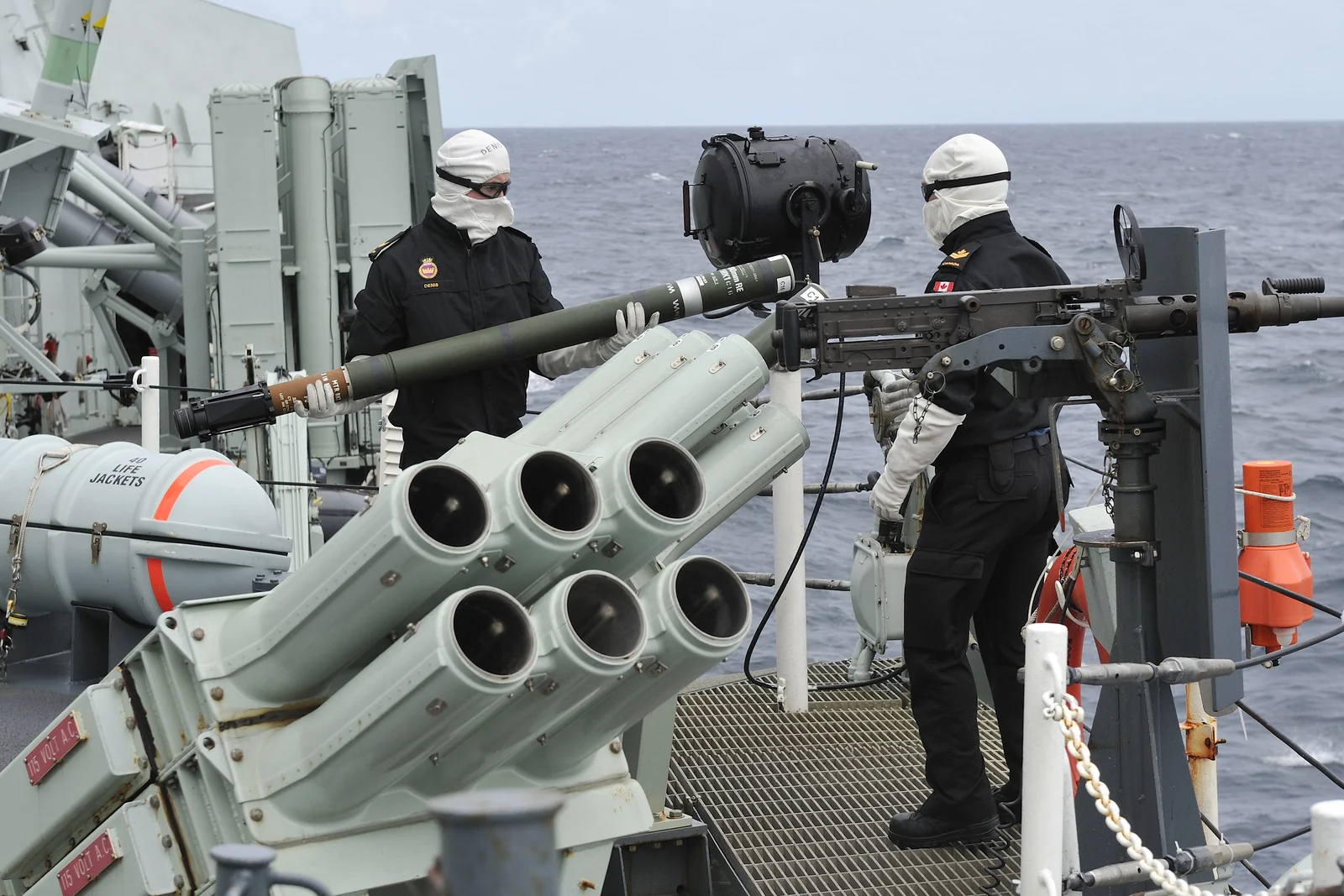 Naval personnel beside a shipboard chaff launcher