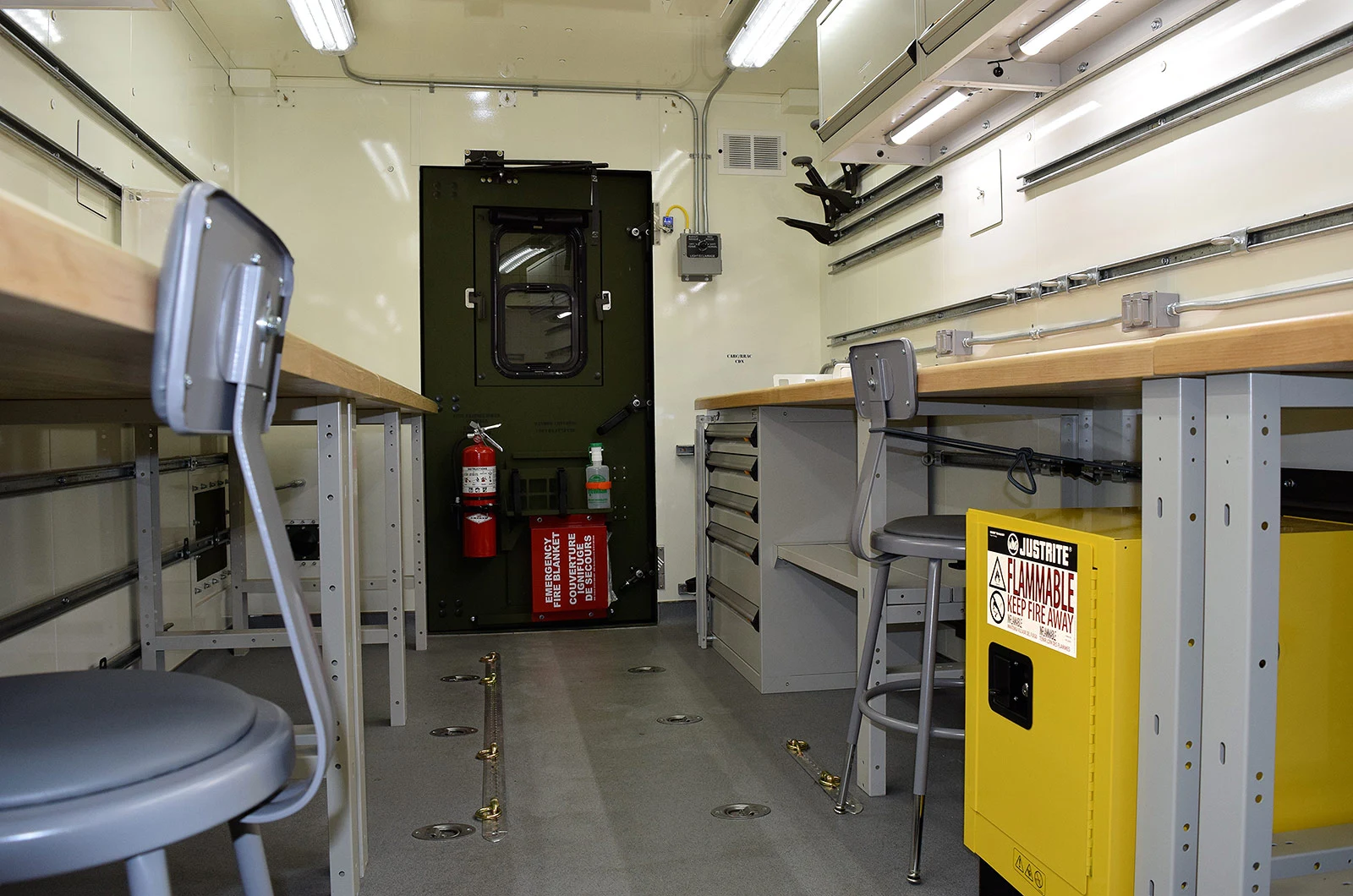 Fitted shelter with workstations, seating and equipment storage